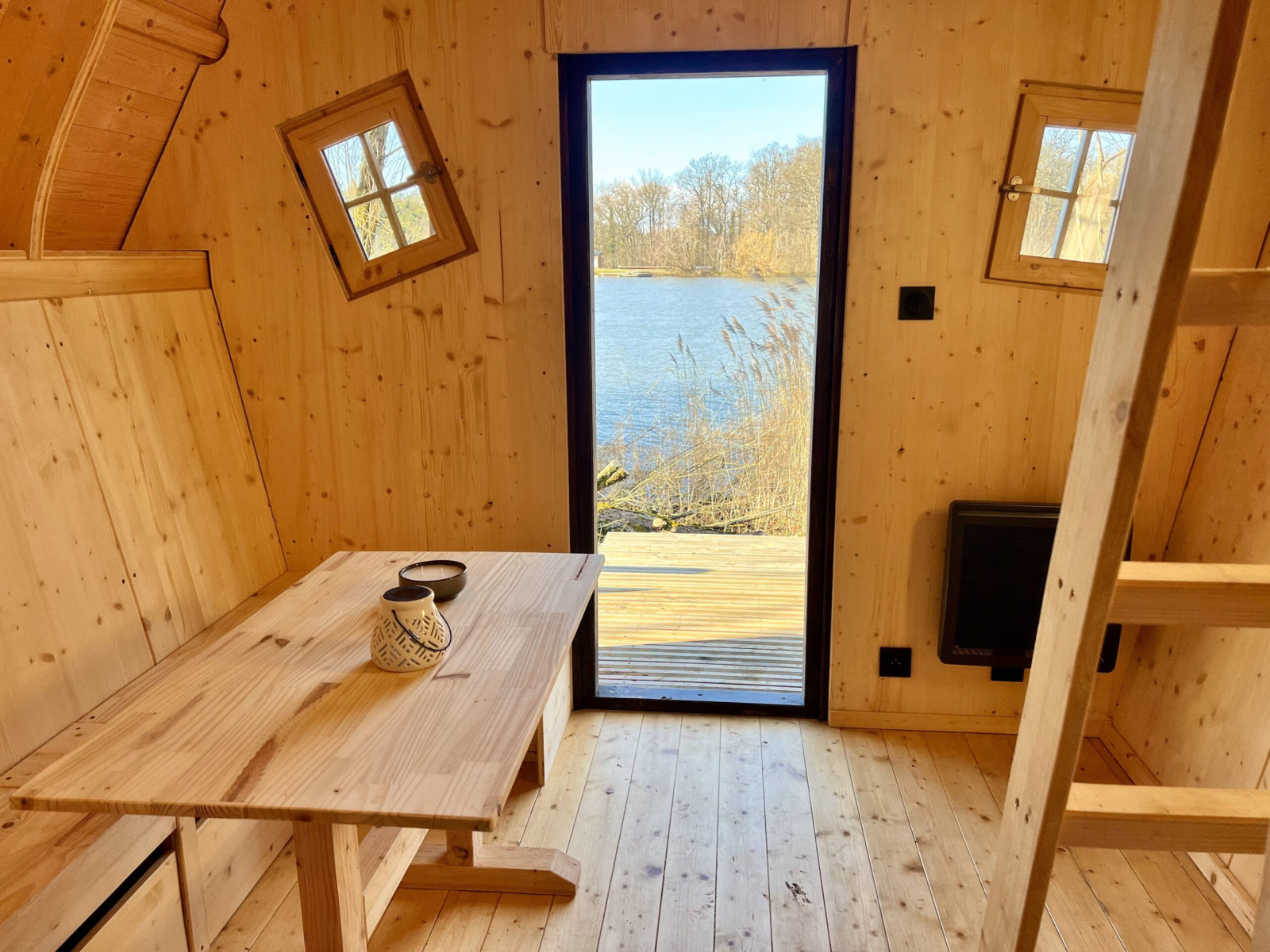 Houten interieur van Cabine Fées lodge bij Domaine des Feuilles, Frankrijk, met uitzicht op het meer.