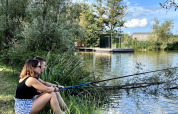 Due persone pescano vicino al lago alla Cabine Spa Miroir al Domaine des Feuilles in Francia, immerse nella natura.