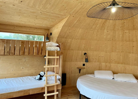 Interieur van Cabine Spa Les Flots met stapelbedden en rond bed bij Domaine des Feuilles, Frankrijk.