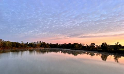 Vredig zicht op een meer bij zonsopgang vanuit Cabine Spa Les Flots, Domaine des Feuilles, Frankrijk.