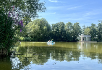 Cabina Lumipod Flottant al Domaine des Feuilles in Francia, circondata da alberi e un lago tranquillo.