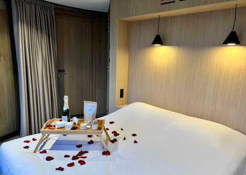 Romantische slaapkamer in Lumipod Flottant bij Domaine des Feuilles, ontbijt op bed en rozenblaadjes.