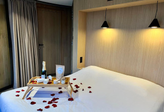 Romantische slaapkamer in Lumipod Flottant bij Domaine des Feuilles, ontbijt op bed en rozenblaadjes.
