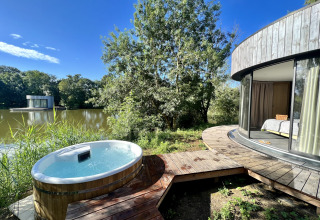 Bubbelbad buiten en ronde Lumipod cabana aan het meer op Domaine des Feuilles in Frankrijk, volle natuur rondom.