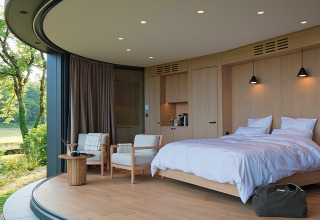 Moderne slaapkamer in Lumipod île bij Domaine des Feuilles, Frankrijk, met grote ramen en houten interieur.