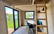 Interiør af et lille hus ved Domaine des Feuilles i Frankrig med spisebord, stole og hemsestige.
