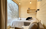 Camera accogliente nella Roseaux Cabin al Domaine des Feuilles, Francia, con grande finestra sulla natura.
