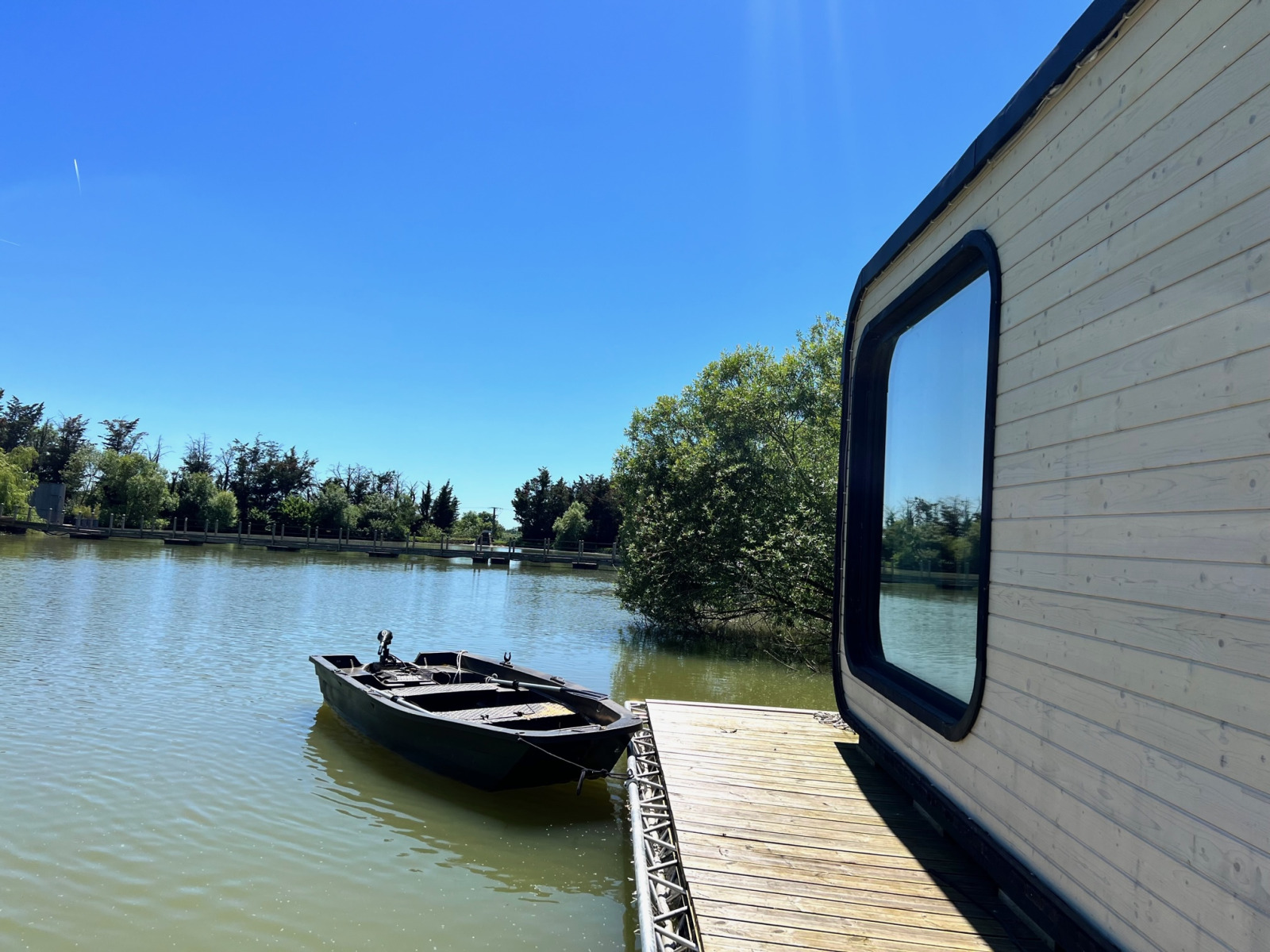 Héron cabin bij Domaine des Feuilles in Frankrijk met zonnig terras, roeiboot en meerzicht.