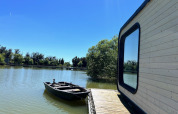 Cabina Héron al Domaine des Feuilles, Francia, con vista su lago, barca e pontile in legno.