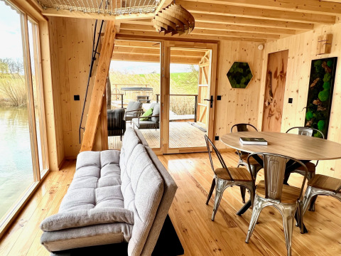 Interieur van de Spa Végétale Cabin bij Domaine des Feuilles in Frankrijk, met houten wanden, bank en tafel.