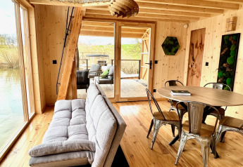 Interni della Spa Végétale Cabin al Domaine des Feuilles in Francia con pareti in legno, divano e tavolo.