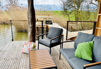 Terrazza della Spa Végétale Cabin al Domaine des Feuilles in Francia, con sedie moderne e vista sulla natura.
