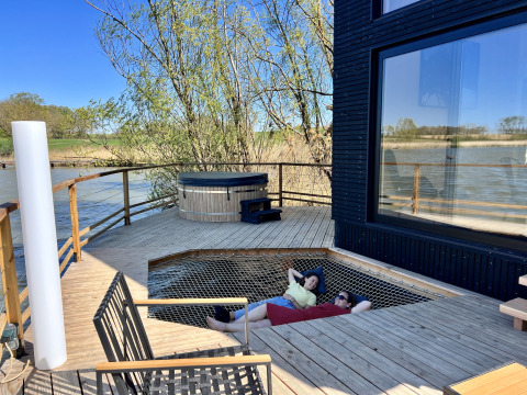 Buitenterras aan Spa Design Cabin in Domaine des Feuilles, Frankrijk, met jacuzzi en luiernet zone.