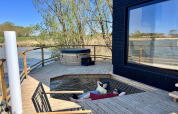 Terrazza esterna alla Spa Design Cabin presso Domaine des Feuilles in Francia, con vasca idromassaggio e rete relax.