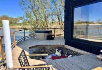 Terrazza esterna alla Spa Design Cabin presso Domaine des Feuilles in Francia, con vasca idromassaggio e rete relax.