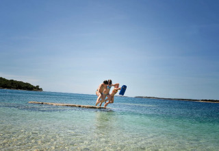 Two people jump together into the clear sea at Camping Brioni, a holiday park in Istria, Croatia.