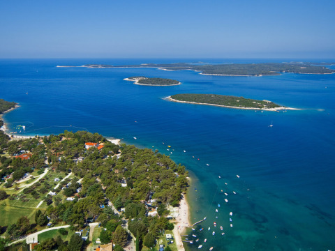 Aerial photo of Camping Brioni in Istria, Croatia, featuring beaches, blue sea, and lush green islands.