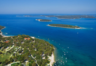 Vue aérienne de Camping Brioni en Istrie, Croatie, plages, mer bleue et îles verdoyantes visibles.