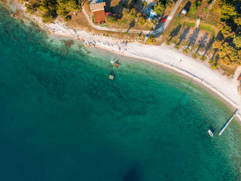 Aerial view of Camping Brioni holiday park in Istria, Croatia, showing the turquoise sea and sandy beach.