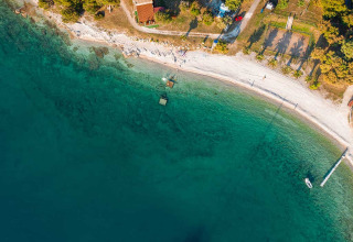 Vista aerea di Camping Brioni in Istria, Croazia, con mare turchese, spiaggia sabbiosa e verde circostante.
