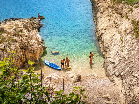 Des vacanciers profitent de la plage rocheuse et de l’eau claire à Valamar Camping Marina, Istrie, Croatie.