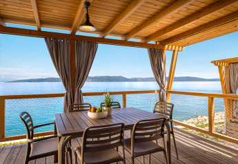Vista dalla cabina Marina Home Spectacular seaview, terrazza con tavolo, sedie e panorama sul mare.