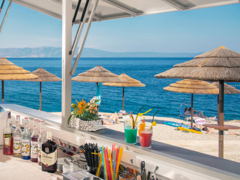 Uitzicht vanaf de strandbar bij Valamar Camping Marina in Istrië, Kroatië, met parasols en cocktails.
