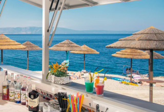 Blick von einer Strandbar im Valamar Camping Marina, Istrien, Kroatien mit Sonnenschirmen und Cocktails.