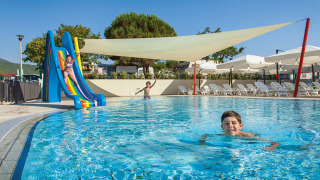 Niños se divierten en la piscina con tobogán en Valamar Camping Marina, un parque vacacional en Istria, Croacia.