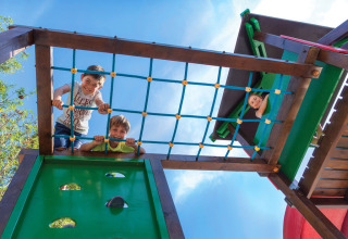Kinderen spelen op het klimnet van een speeltuin bij Valamar Camping Marina, Istrië, Kroatië.