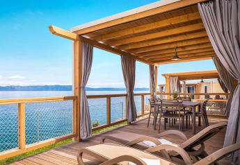 Terrasse en bois avec transats et table à Marina Home Spectacular seaview, Valamar Camping Marina, Croatie.