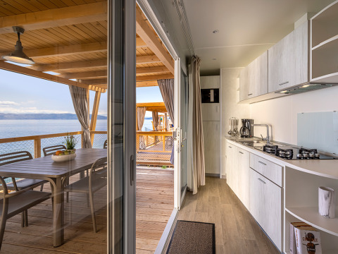 Moderne keuken en eetruimte op terras met zeezicht bij Marina Home, Valamar Camping Marina, Kroatië.