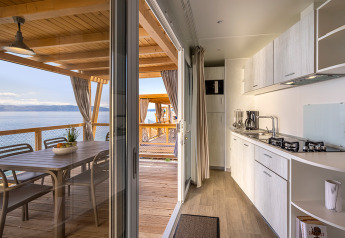 Moderne køkken og spiseplads på træterrasse med havudsigt på Marina Home, Valamar Camping Marina, Kroatien.