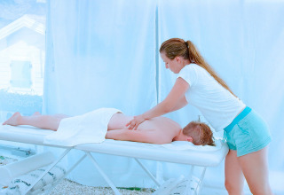 Een persoon ontvangt een ontspannende massage in een lichte behandelruimte bij Valamar Camping Marina in Istrië, Kroatië.
