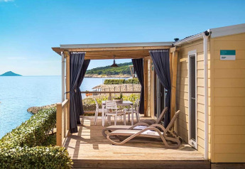 Cabina Marina Home Seaside con terrazza solarium, sedie a sdraio e vista mare in una giornata di sole