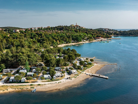 Luftaufnahme vom Camping Orsera Ferienpark an der Küste Istriens, Kroatien, mit Wald und Strand.