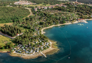 Aerial view of Vrsar area in Istria, Croatia, showing coastline, greenery, campsites, and clear blue sea.