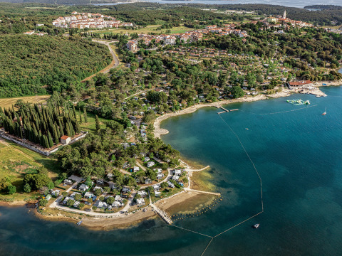 Vista aérea de la zona de Vrsar en Istria, Croacia, con costa, vegetación, casas y camping junto al mar azul.
