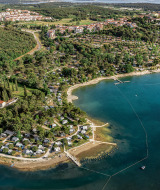 Luchtfoto van Vrsar in Istrië, Kroatië, met kustlijn, groen, campings en het heldere blauwe zeewater.