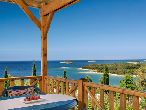 Vista da Orsera Home al Camping Orsera in Croazia con terrazza, mare e piccole isole all'orizzonte.