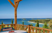 Vista da Orsera Home al Camping Orsera in Croazia con terrazza, mare e piccole isole all'orizzonte.