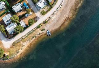Vue aérienne du Camping Orsera en Istrie, Croatie, avec camping-cars et bateaux alignés au bord de l'eau.
