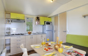 Cucina moderna e zona pranzo in Orsera Home al Camping Orsera, Croazia, apparecchiata per la colazione.