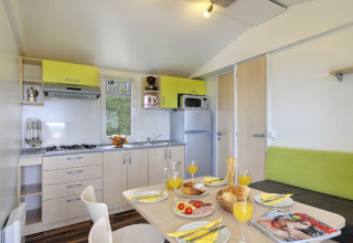 Cucina moderna e zona pranzo in Orsera Home al Camping Orsera, Croazia, apparecchiata per la colazione.
