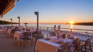 Buitenterras van Camping Orsera in Istrië, Kroatië met zeezicht en zonsondergang over het water.