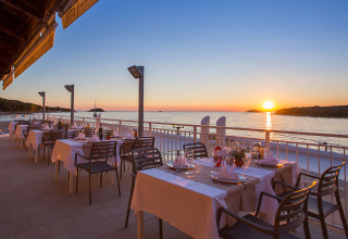 Dining terrace at Camping Orsera in Istria, Croatia with ocean view and sunset over the Adriatic Sea.