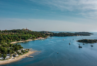 Udsigt over Camping Orsera feriepark i Istrien, Kroatien med strand, skov, både og malerisk landskab.