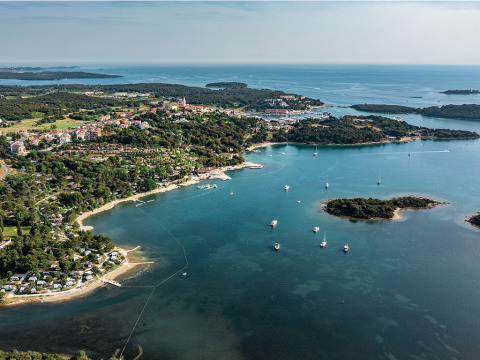 Luftaufnahme des Campingplatzes Orsera in Istrien, Kroatien, mit Segelbooten und grünem, bewaldetem Ufer.