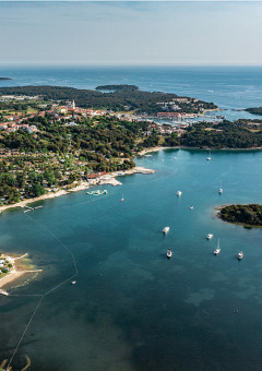 Luchtfoto van vakantiepark Camping Orsera in Istrië, Kroatië, met kustlijn, boten en groene gebieden.