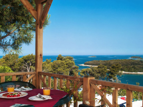 Vista da Orsera Home al Camping Orsera in Croazia, con terrazza, mare cristallino e isole verdi sullo sfondo.